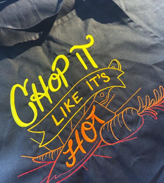 Tablier noir “Chop it like it’s hot” brodé (jaune-orange-rouge)
